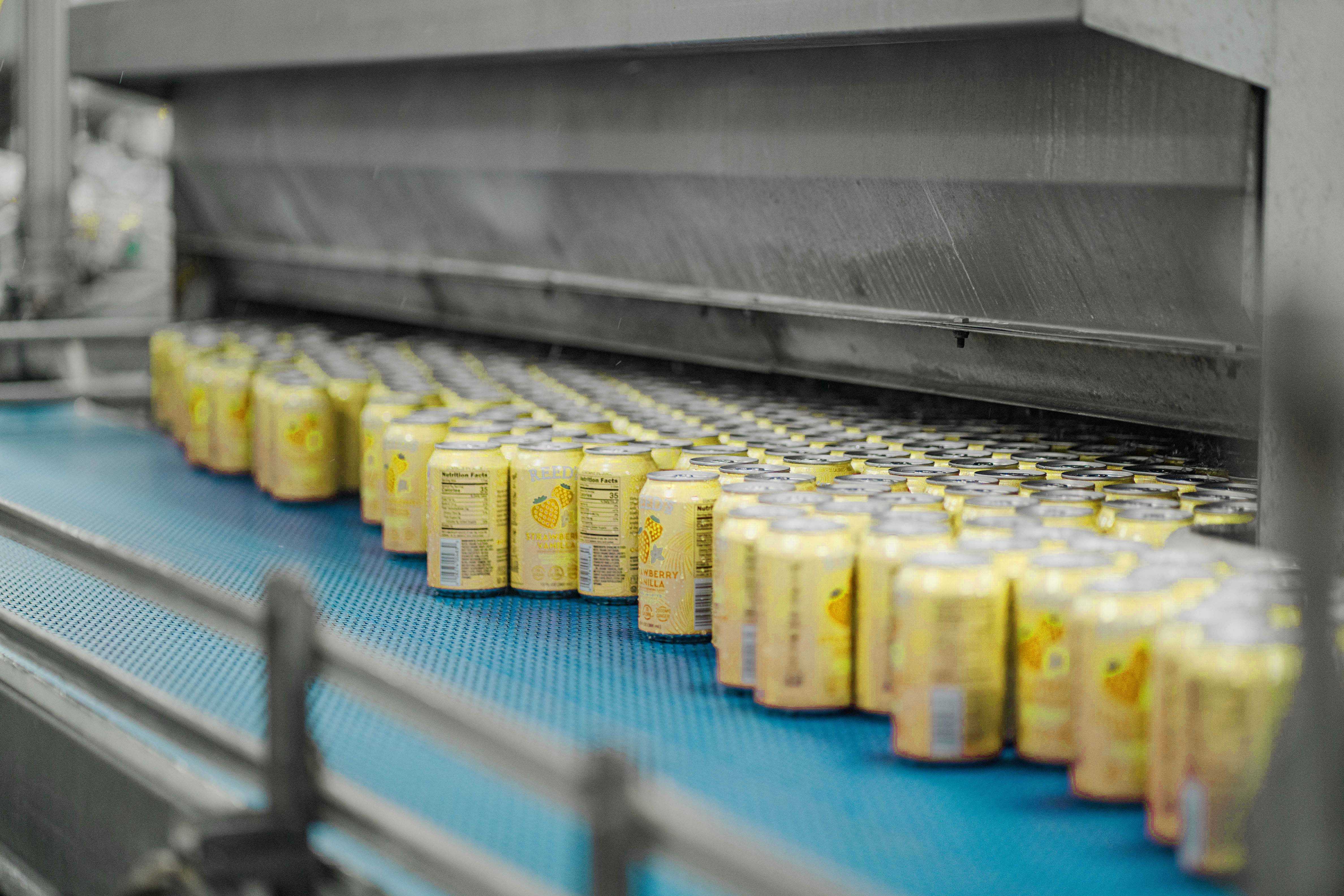 Yellow cans on conveyor belt in canning facility